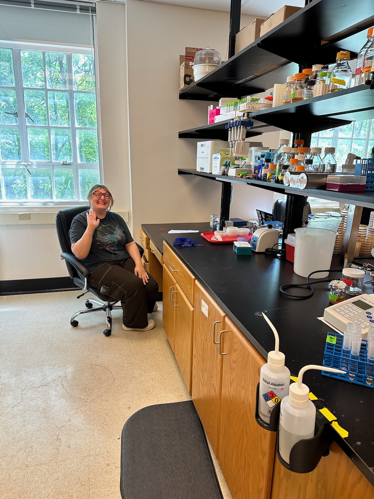 Photograph of Madeline sitting at her new bench in the lab.